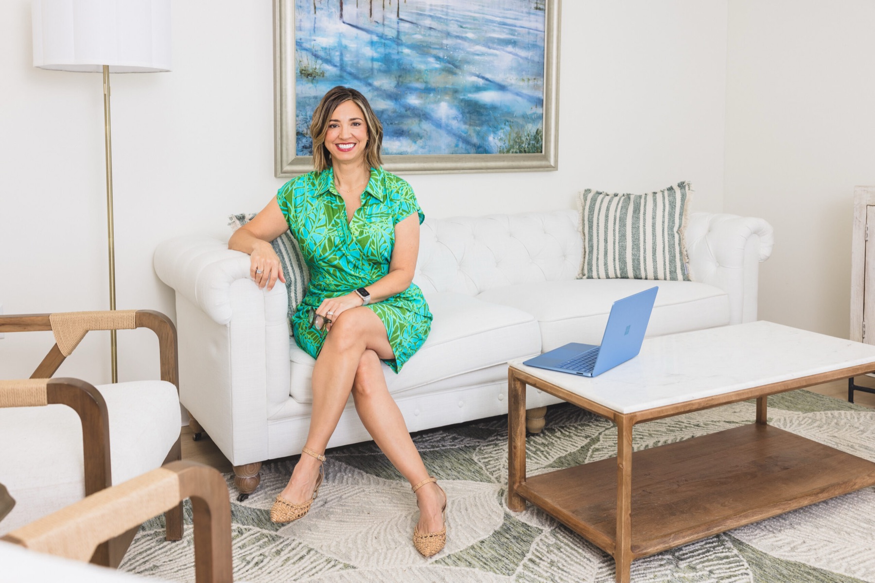 Meg Corrigan, APRN, seated on a white sofa in her bright St. Augustine office